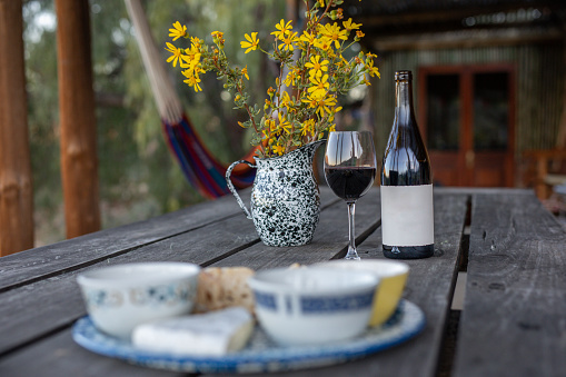 White wine bottle and glass on wooden table. Outdoor still life. With space for your text