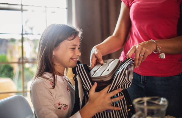 Making school lunch box Mother preparing healthy snacks lunch boxes for daughter school lunch child food lunch stock pictures, royalty-free photos & images