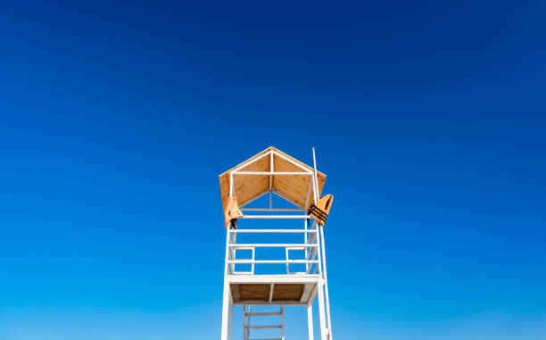 istock white wooden lifeboat tower on beach against sky. 1268160562
