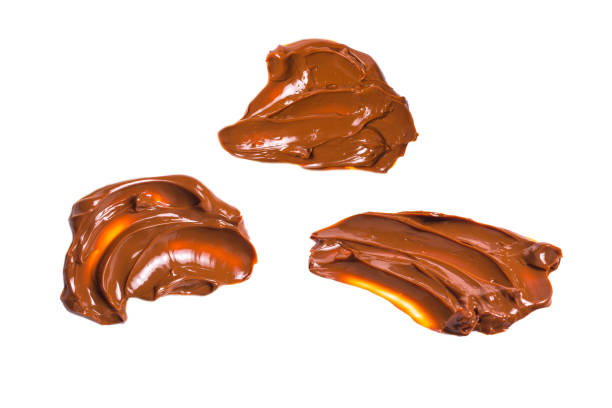 istock Melted tasty caramel splashes isolated on white background. 1268163274