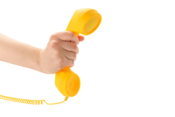 Yellow handset in woman hand isolated on white. Copy space.