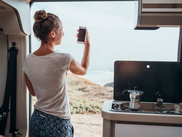 istock Woman drinking coffee and checking phone in motorhome 1268169245