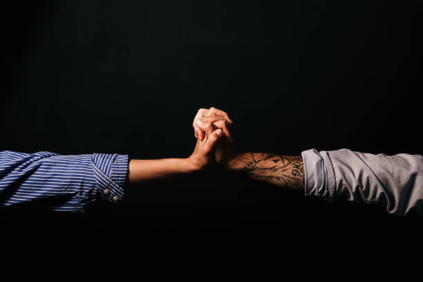 Connection of two male and female hands isolated on a studio background Connection of two male and female hands isolated on a studio background. Conceptual image, close up forearm tattoos men stock pictures, royalty-free photos & images