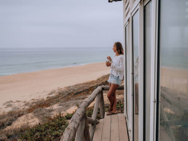 istock Woman drinking coffee on beach 1268174257