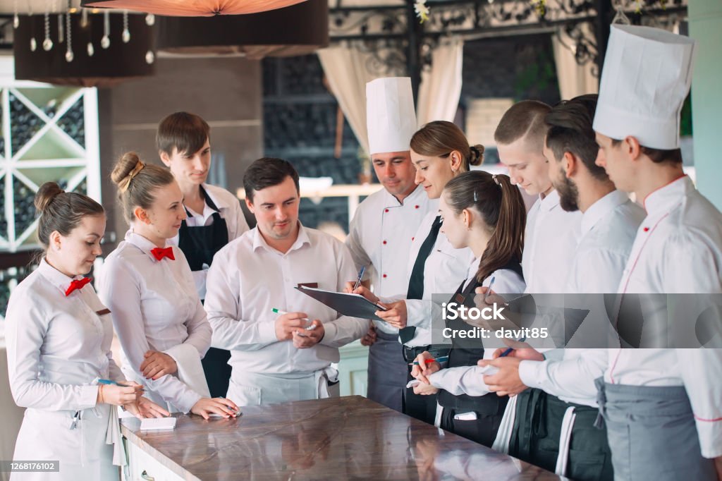 Restaurant manager and his staff in terrace. interacting to head chef in restaurant. Restaurant manager and his staff in terrace. interacting to head chef in restaurant Teamwork Stock Photo