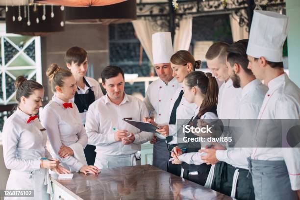Restaurant Manager And His Staff In Terrace Interacting To Head Chef In Restaurant Stock Photo - Download Image Now