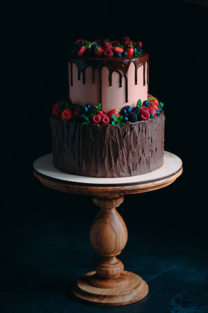 istock Fruit chocolate cake on wooden stand on black background. 1268177201