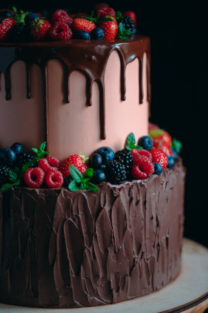 istock Fruit chocolate cake on wooden stand on black background. 1268177224