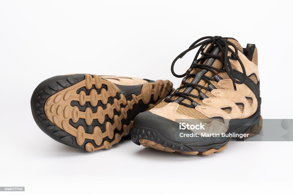 Light brown women's hiking shoes with a visible shoe sole Pair of light brown women's hiking shoes made of leather, shoe sole visible. With a white background. Hiking Boot Stock Photo