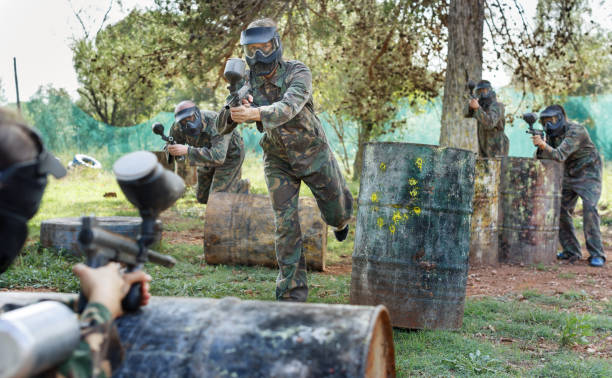 istock Paintball players aiming and shooting with guns 1268178775