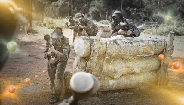 istock Paintball players aiming and shooting with guns 1268178785