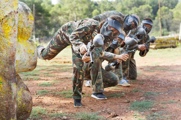 istock Paintball team running with marker guns 1268178787