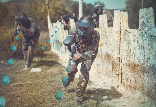 istock Female paintball player aiming in shootout 1268178798