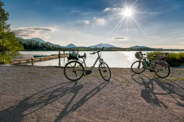 Bathing beach with wooden landing stage at the Hopfensee, in the background the Alp Mountains, Bavaria, Germany