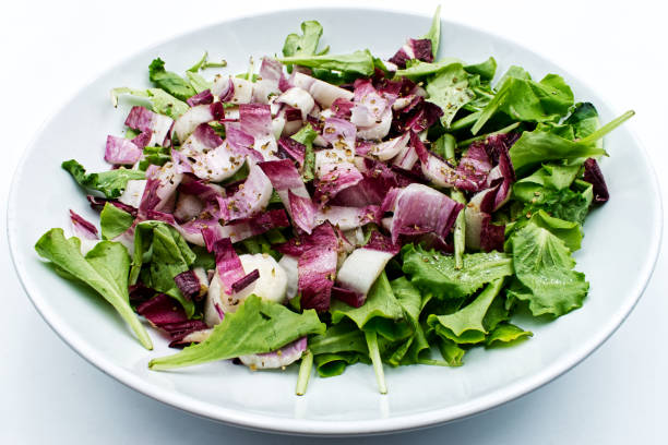 Fresh mixed lettuce salad in a dish isolated on white