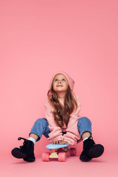 Studio portrait of a cute girl with skateboard Studio portrait of a cute girl with skateboard girl sitting stock pictures, royalty-free photos & images