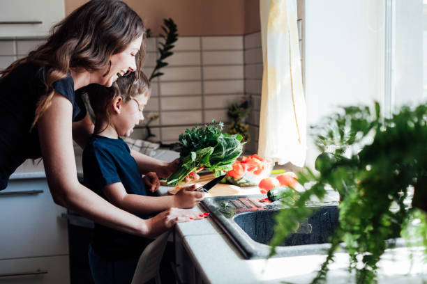 istock Little son helps mom cook vegetable salad in the kitchen 1268184358