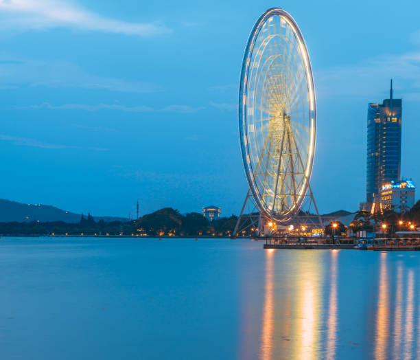In the evening, overlooking the Ferris wheel in the distance on the edge of Taihu Lake, Wuxi, China In the evening, overlooking the Ferris wheel in the distance on the edge of Taihu Lake, Wuxi, China wuxi photos stock pictures, royalty-free photos & images
