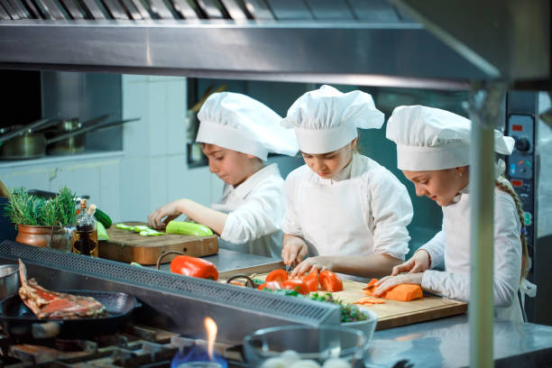 istock Children grind vegetables in the kitchen of a restaurant. 1268186090