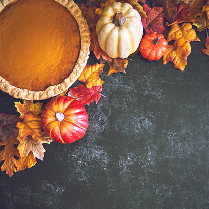 Autumn Decoration with Leafs and Pumpkin Pie on Rustic Background