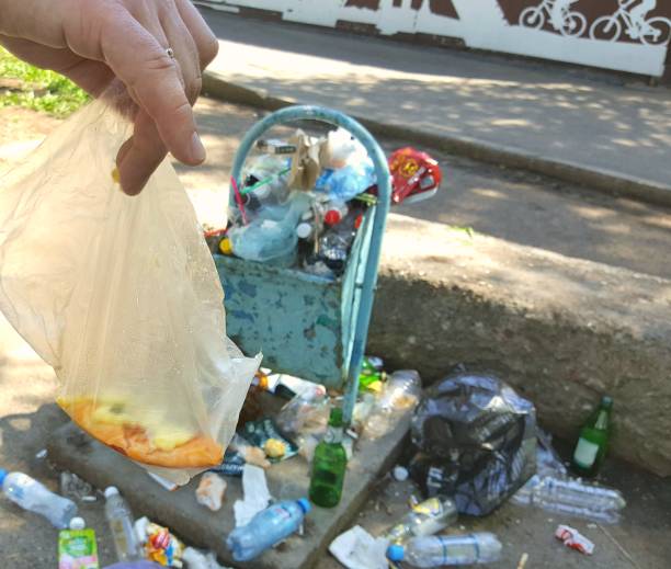 istock Hand throws garbage into a tank on the street 1268187903