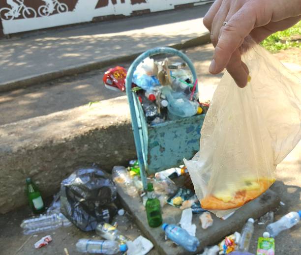 istock Hand throws garbage into a tank on the street 1268187916