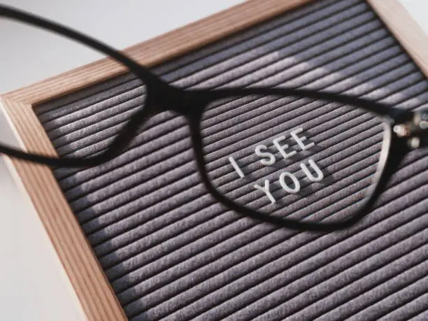 Letterboard with words I SEE YOU through eyeglasses. Closer look on ignore, abuse, gaslighting, other psychological manipulation. Salvation of psychological problems.