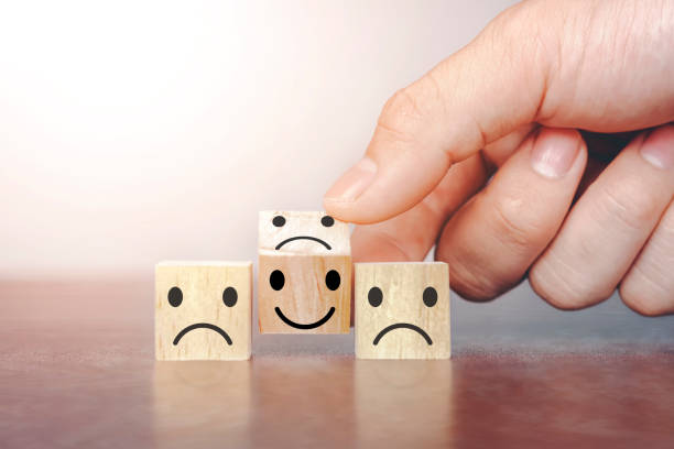 istock Hand flip over wooden cube block with happy smile symbol 1268193435