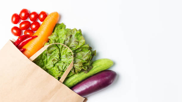 istock Various vegetables and fruits in paper bag on white background, copy space 1268198008