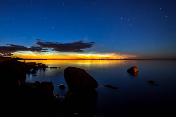 istock Dawn on lake. Feathered clouds glow at dawn. 1268206136