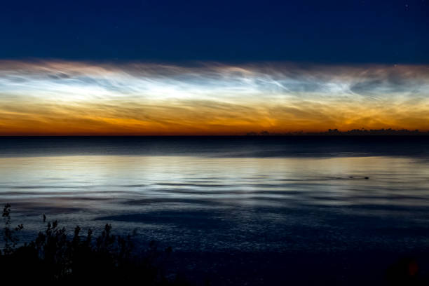 istock Dawn on lake. Feathered clouds glow at dawn. 1268206147