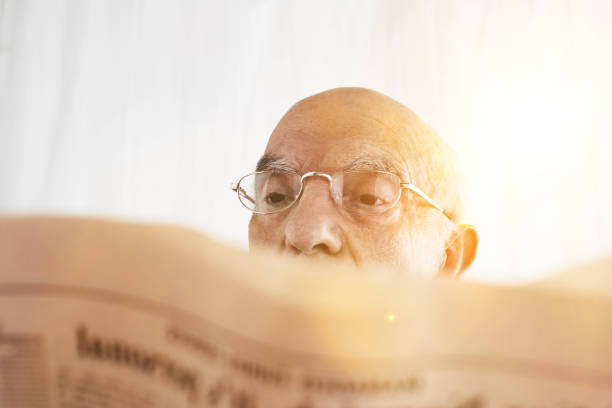 Senior Man reading his financial newspaper with sunshine