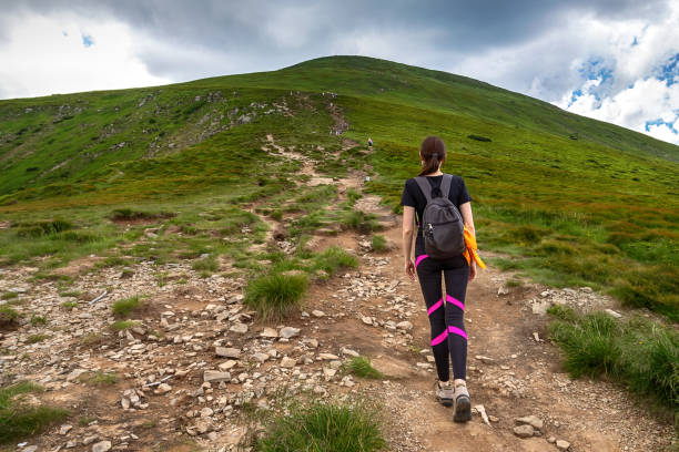 istock A young girl with a backpack climbs a mountain. Beautifull cloudy sky. Leisure. Hiking. Hoverla Mountain. Ukraine. 1268208035