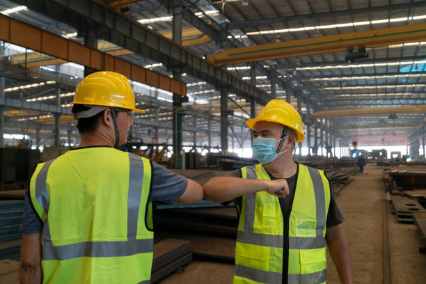 istock Two Asian male engineers greet their elbows at the construction site 1268208246