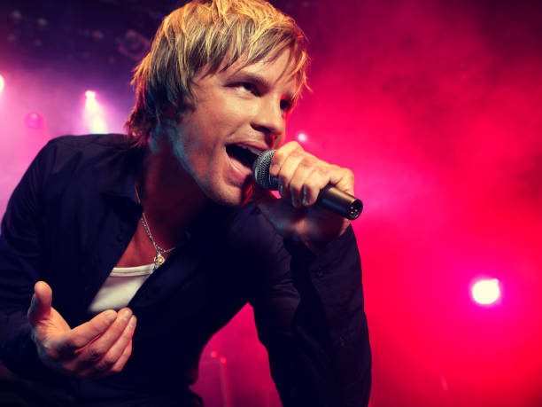 istock Young Man Singing at rock Concert 1268214295