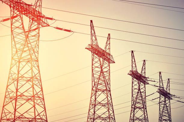 istock Four pwer transmission towers silhouettes at sunset. 1268215630