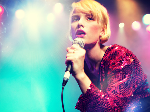 Young female rockstar Singing in Concert