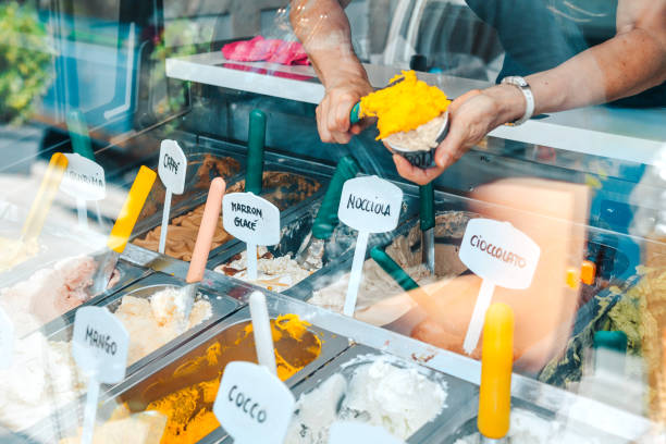 femme ayant la crème glacée dans un magasin italien de crème glacée - gelato photos et images de collection