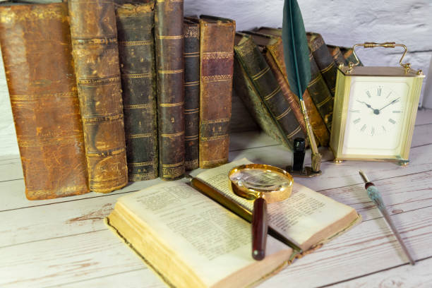 istock antique open book with a magnifying glass and antique writing pen 1268217739