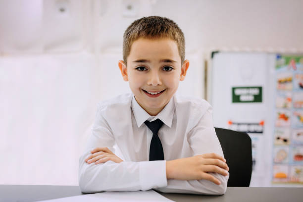 istock Cute little boy posing for a photo in a school uniform 1268219904
