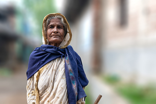 A poor and old woman of India from the tribal community looking at the camera with astonishing eyes. The lifestyle of the poor Indian villagers.