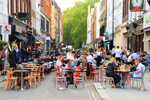 Bar and restaurant outdoor street seating in Soho, London London, United Kingdom - August 21 2020: Social distancing bar and restaurant outdoor street seating in Soho with crowd of people covent garden photos stock pictures, royalty-free photos & images