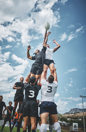 Shot of two rugby teams competing over a ball during a line out of a rugby match outside on a filed