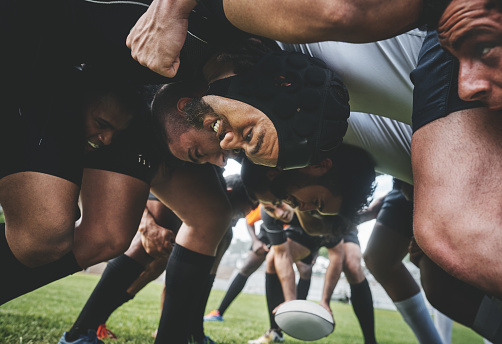 Low angle shot of two young rugby teams competing in a scrum during a rugby match on a field