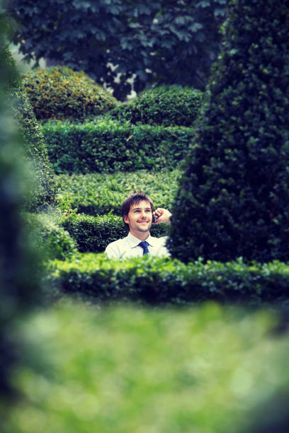 istock Businessman Talking on Cell  Phone in Garden 1268224710