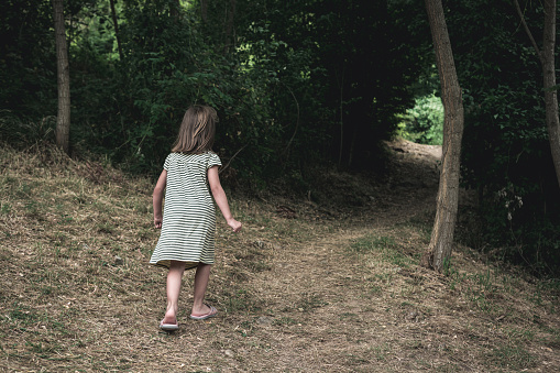 Little girl walking through forest