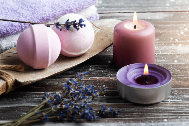 Vanilla aroma bath bombs in spa Vanilla aroma bath bombs in spa composition with dry lavender flowers and towels. Aromatherapy arrangement, zen still life with lit candles massage oil photos stock pictures, royalty-free photos & images