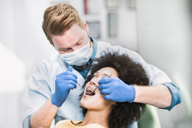 istock Dentist using a probe and a dental mirror to perform a regular dental check up 1268228684