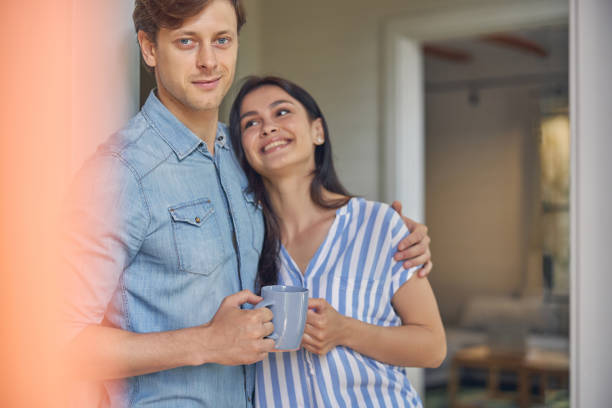istock Smiling man hugging his girlfriend in the house 1268232748