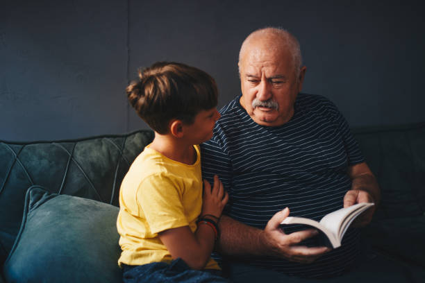istock Grandfather reading with his grandson 1268234522